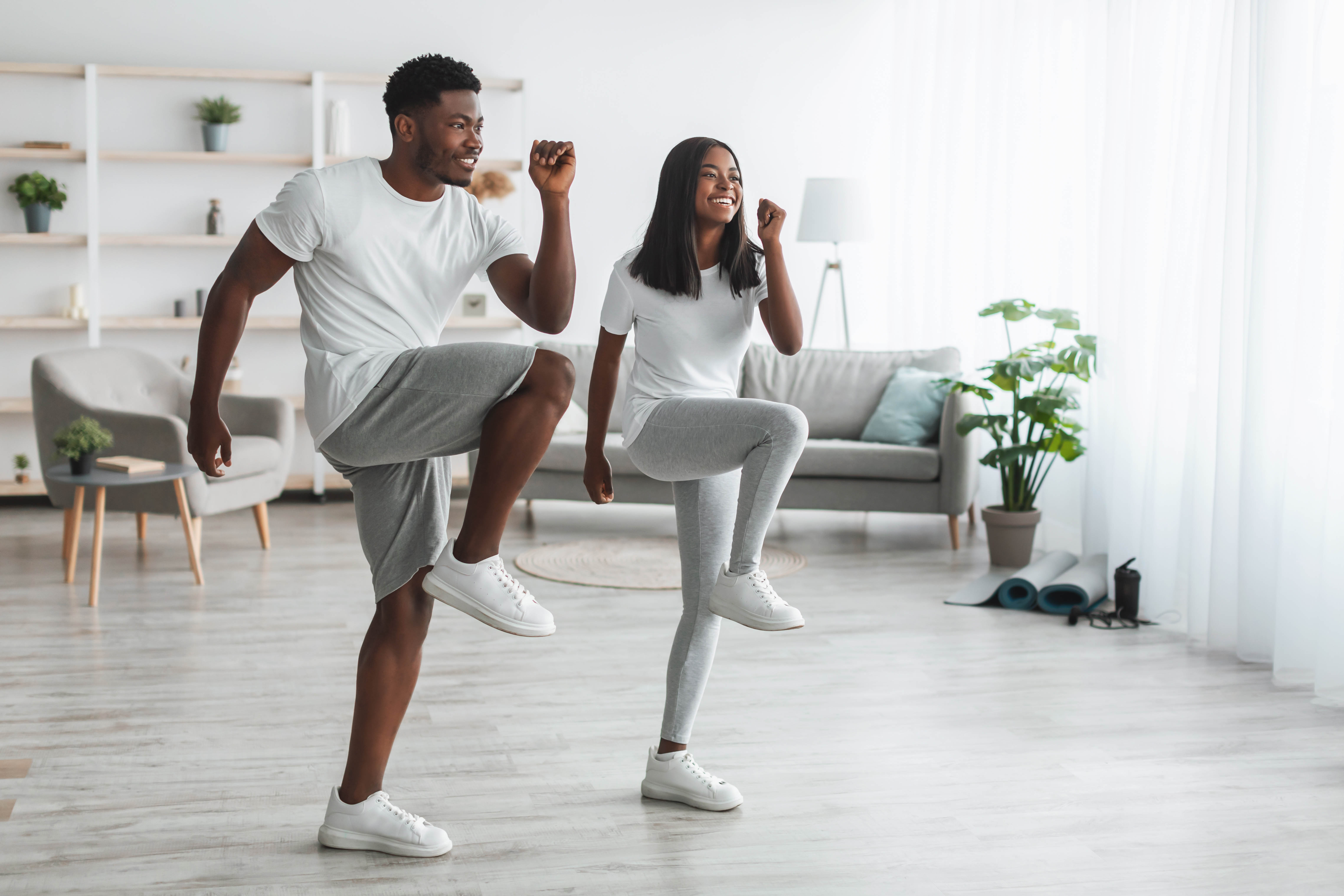 Young African American couple completes an at-home workout in their living room
